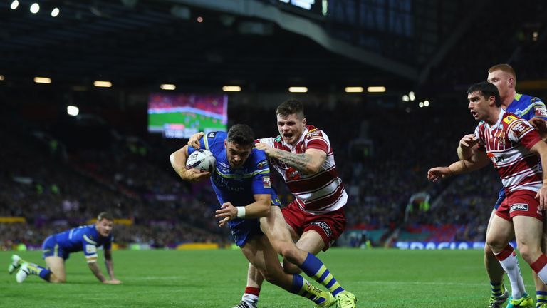 Declan Patton of Warrington scores the opening try despite the challenge from John Bateman of Wigan