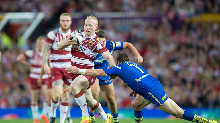 Wigan's Liam Farrell evades the tackle of Warrington's Kurt Gidley