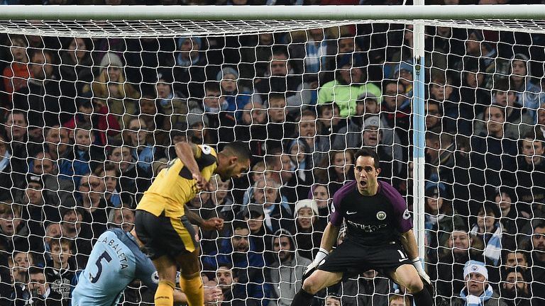 Theo Walcott scores his team's first goal past Manchester City's Chilean goalkeeper Claudio Bravo