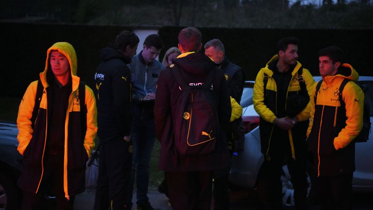 Borussia Dortmund players wait after their team bus was damaged by three explosions