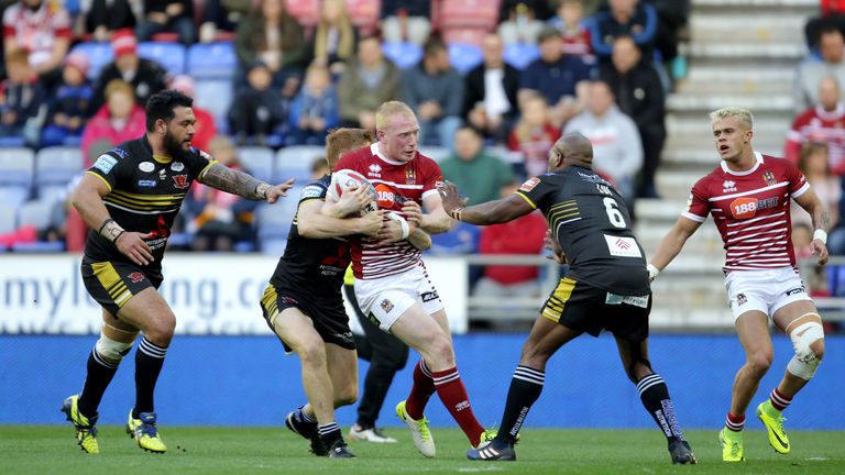 Wigan Warriors' Liam Farrell (centre) is tackled by Salford's Ben Murdoch-Masila (left) and Robert Lui (right) 