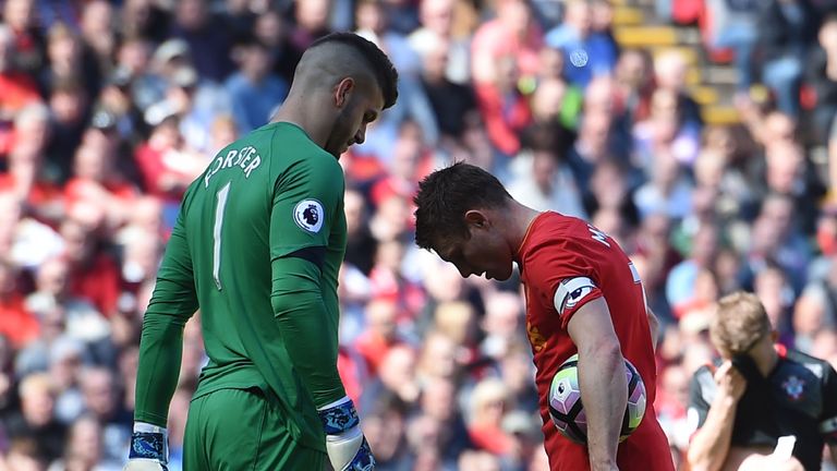 Southampton's Fraser Forster eyes up Liverpool's English midfielder James Milner before the spot-kick is taken