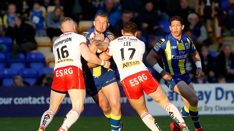 Warrington Wolves' Mike Cooper is tackled by St Helens Luke Thompson (left) and Tommy Lee (right)