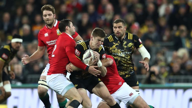 Hurricanes' Jordie Barrett is tackled by Lions duo Robbie Henshaw and Rory Best