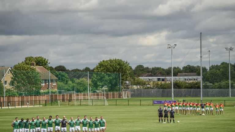 Players from London and Carlow stand for the national anthem 