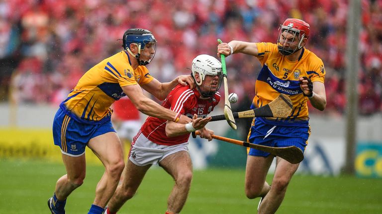 Two Clare defenders try to halt Cork's Luke Meade