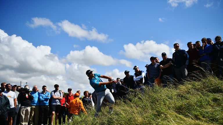 Rahm plays a shot out of the rough during the first round of The Open