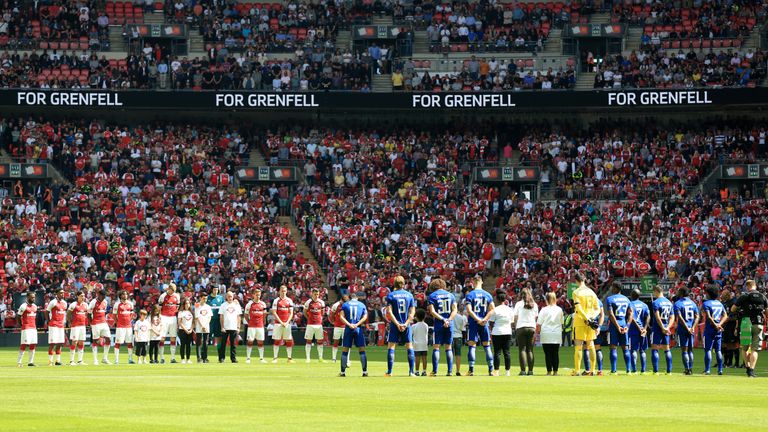 Both teams stand to remember the victims of the Grenfell Tower fire