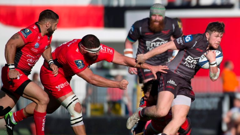 Scarlets' Steffan Evans (R) avoids Toulon defenders during the first round of the European Champions Cup 