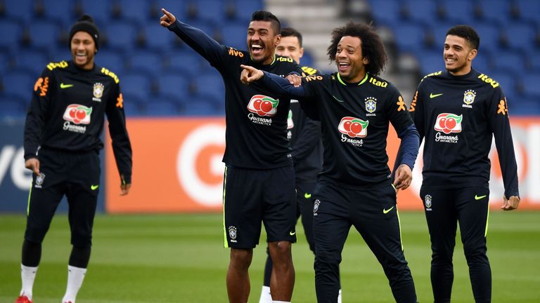 Brazil's midfielder Paulinho (L) jokes with defender Marcelo during a training session