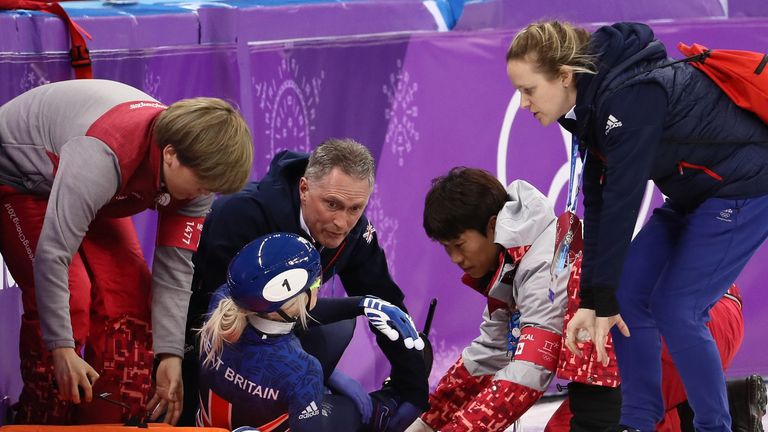 Elise Christie is treated by medics before being stretchered off the ice