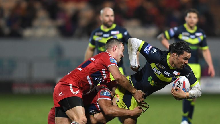 Justin Horo is tackled by Danny McGuire and Maurice Blair