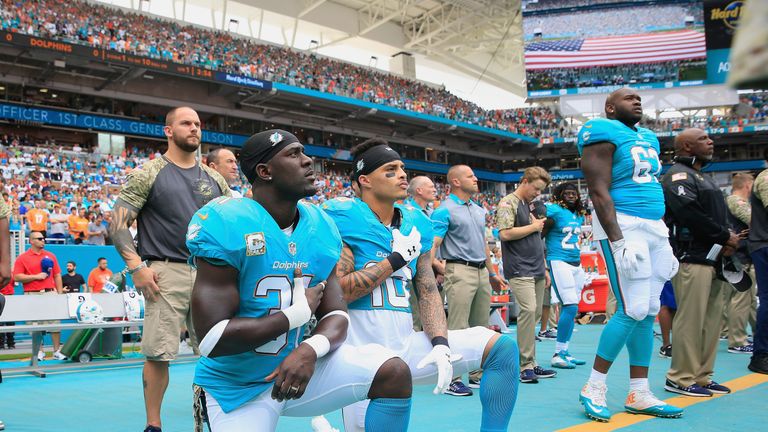 Michael Thomas #31 and Kenny Stills #10 of the Miami Dolphins take a knee during the national anthem