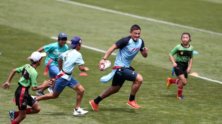 Former Japan full-back Ayumu Goromaru plays with children before the opening ceremony