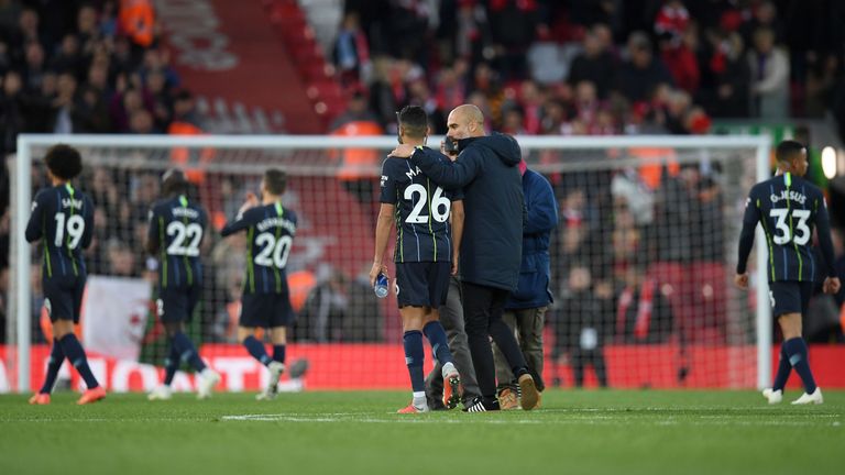 Pep Guardiola puts his arm around Riyad Mahrez as they leave the pitch at Anfield