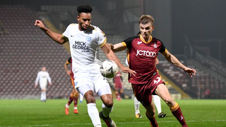Peterborough's Rhys Bennett (L) competes with Bradford's George Miller