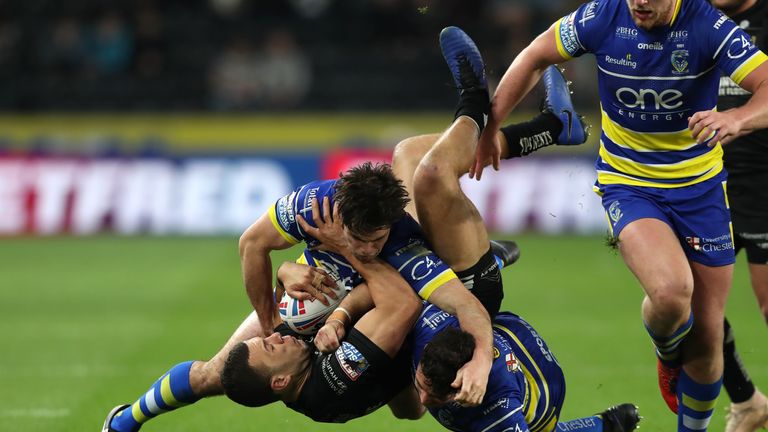 Carlos Tuimavave is tackled by Warrington Wolves' Jake Mamo and Declan Patton
