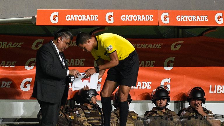 The fourth official goes through the hand-made signs on the touchline