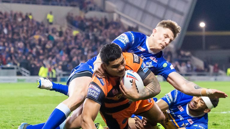 Peter Mata'utia is tackled by Leeds' Liam Sutcliffe and Kallum Watkins