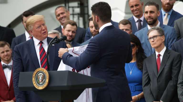 El presidente Trump recibe una camiseta de J.D.Martinez de los Medias Rojas de Boston en 2018 mientras el propietario principal John W Henry observa