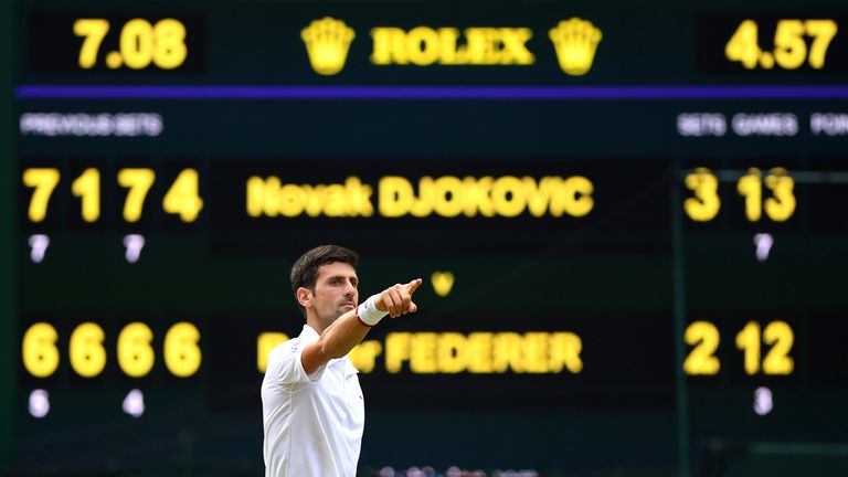 Djokovic celebrates with the electronic scoreboard in the background