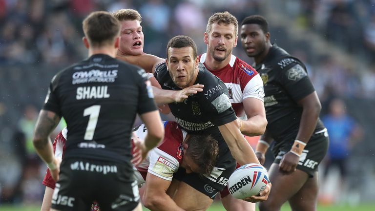 Hull FC's Carlos Tuimavave is tackled by Wigan Warriors Morgan Smithies (l), Sam Powell and Sean O'Loughlin (r)