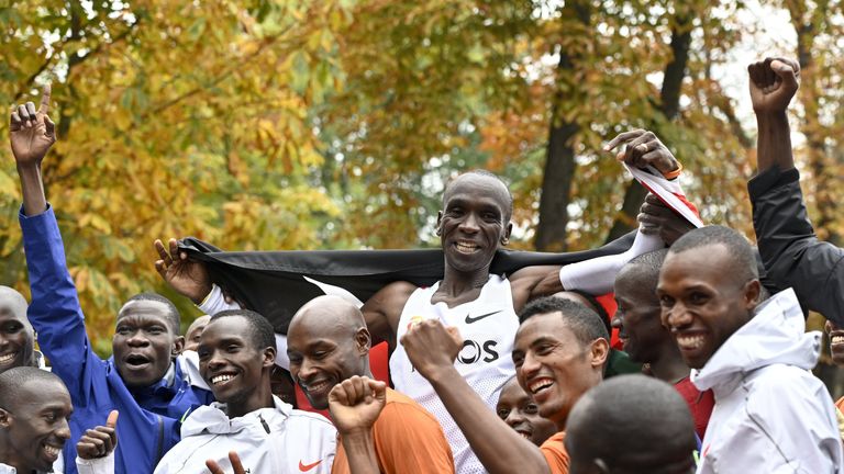 Kenya's Eliud Kipchoge (white jersey) celebrates after busting the mythical two-hour barrier for the marathon in Vienna