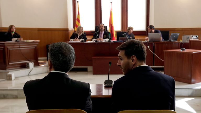Lionel Messi and his father Jorge listen as they face judges in a tax fraud case at the courthouse of Barcelona