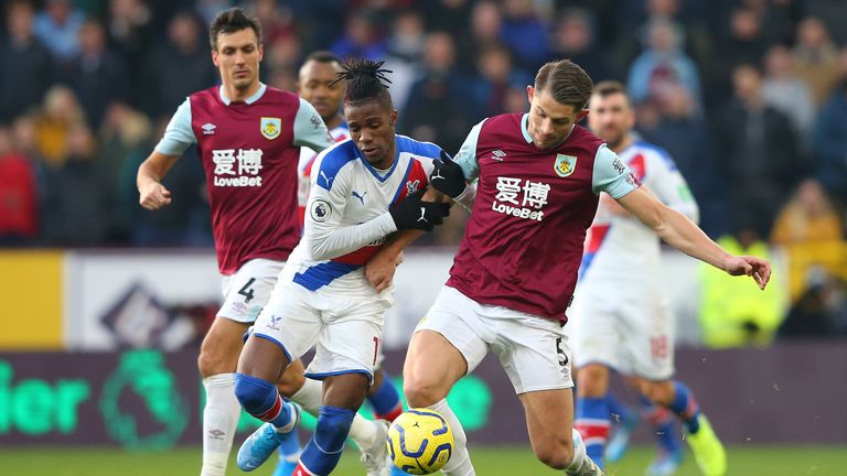 Zaha challenges for the ball with Burnley's James Tarkowski