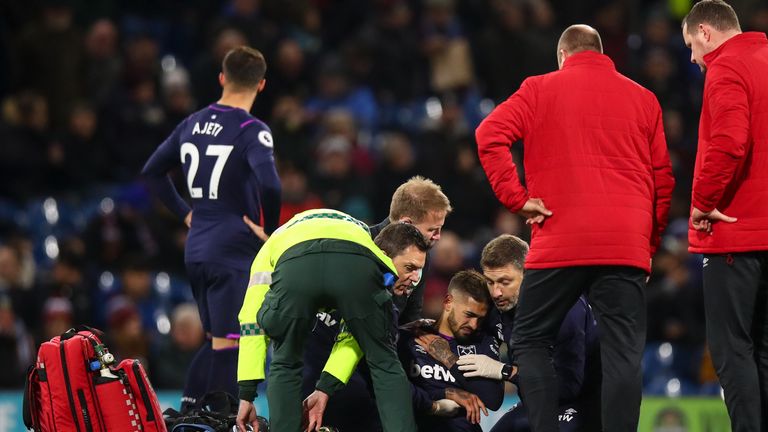 Lanzini se sostiene el hombro mientras recibe tratamiento médico en el campo en Turf Moor