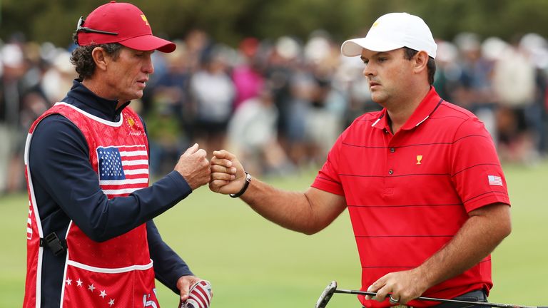 Reed y su caddie y entrenador de columpios Kevin Kirk golpean los puños después del primer hoyo el domingo