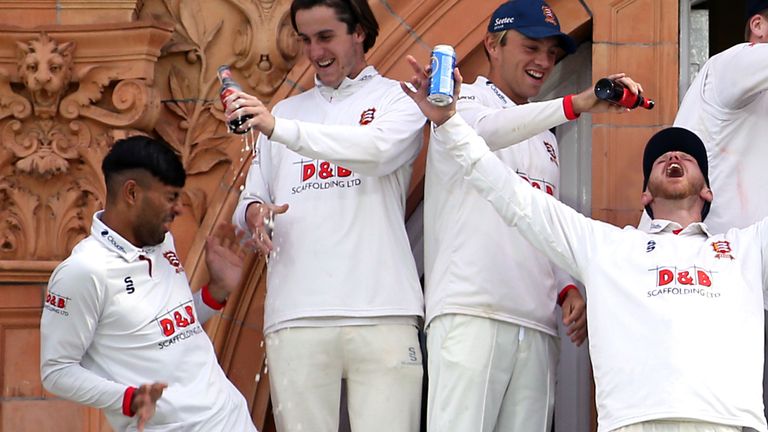 Feroze Khushi recoils as beer is poured over him during celebrations