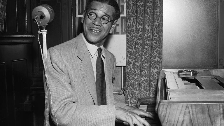 A photo of ex-Olympic sprinter Jack London playing the piano in 1954