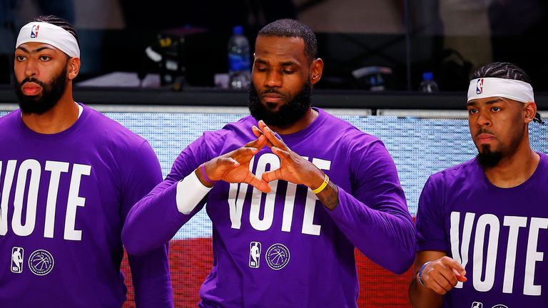 Anthony Davis, LeBron James and Quinn Cook of the Los Angeles Lakers kneel during the National Anthem