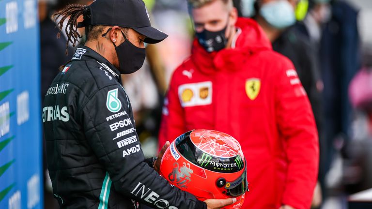A very special moment as Mick Schumacher presents Lewis Hamilton with one of his father's crash helmets after the Briton equalled the F1 wins record