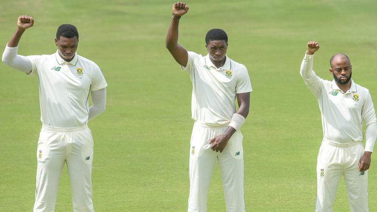 South African players Lungi Ngidi, Lutho Sipamla and Temba Bavuma raise their fists before the first test against Sri Lanka