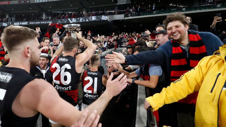 Essendon players celebrate their win with the crowd in Melbourne