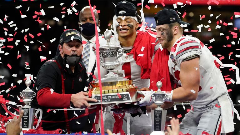 Ohio State head coach Ryan Day, quarterback Justin Fields and linebacker Tuf Borland hold up the trophy after the team's win against Clemson in the Sugar Bowl. (AP Photo/John Bazemore)