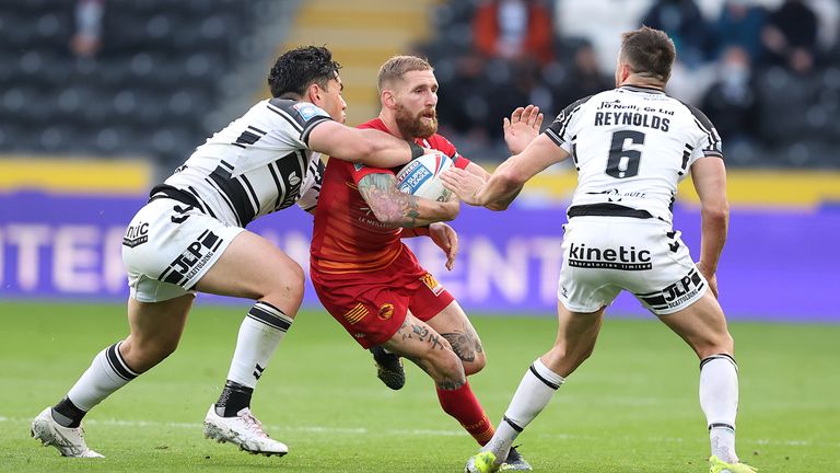 Sam Tomkins in action with Hull FC's Andre Savelio and Josh Reynolds