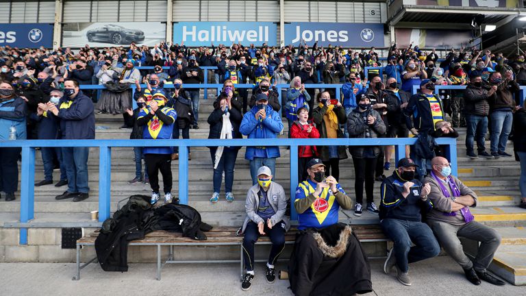 Warrington Wolves fans applaud the players as they come out