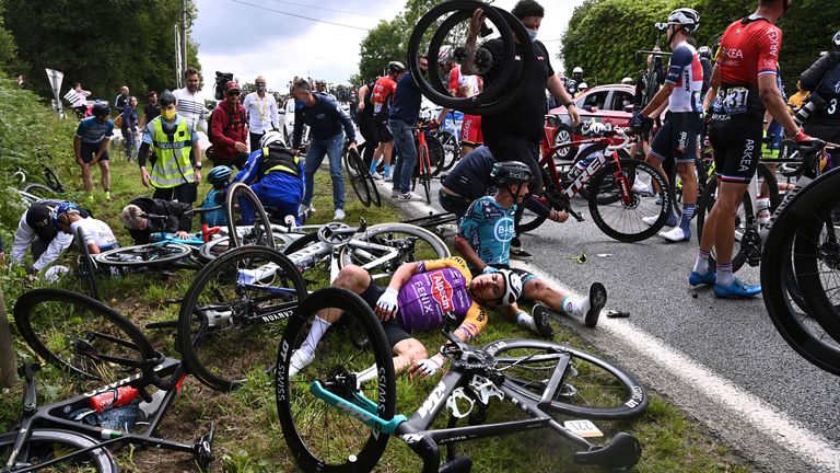 Kristian Sbaragli (left) and Bryan Coquard, (right) lie on the ground after crashing during the first stage of the Tour de France