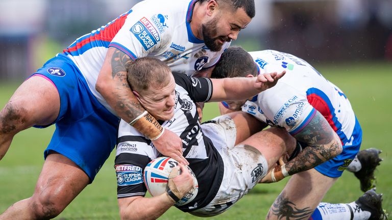 Jordan Johnstone is tackled by Wakefield duo David Fifita and Jay Pitts