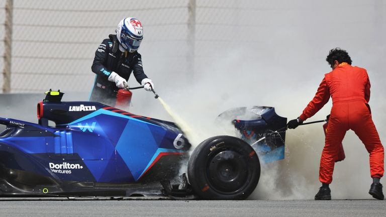 Nicolas Latifi's rear brakes catch fire on his Williams on day two of testing in Bahrain so he grabs a fire extinguisher and helps put out the flames