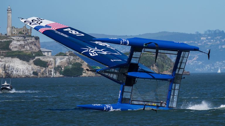 The USA SailGP team capsizes as they sail past Alcatraz Island during a practice session on San Francisco Bay
