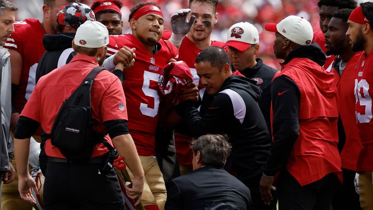 El personal de los Niners ayuda a Lance a subir al carrito. 