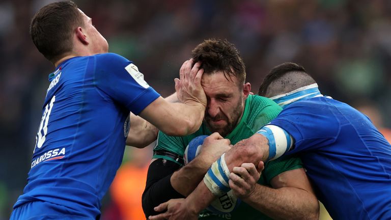 Jack Conan locks horns with two Italian tacklers