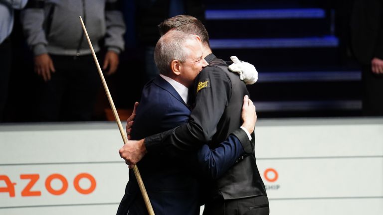 Mark Selby abraza al árbitro Brendan Moore después de hacer un quiebre de 147 en la final