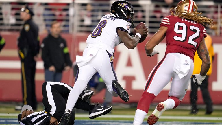 Umpire Alex Moore falls as Baltimore Ravens quarterback Lamar Jackson (8) runs from San Francisco 49ers defensive end Chase Young (92) during the first half
