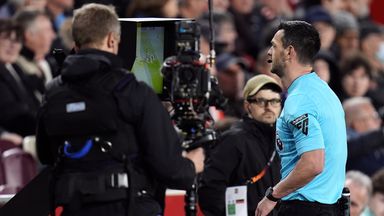 Referee Andrew Madley checks the pitch-side VAR monitor for a potential penalty