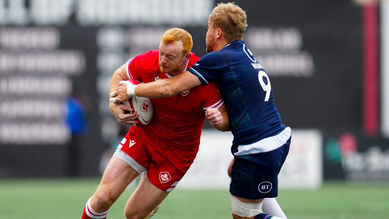 Canada's Peter Nelson is tackled by scrum-half Gus Warr